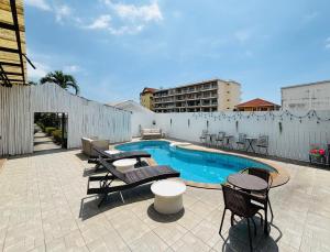 a patio with a pool and chairs and a building at 1715 House - White Rhino in Rawai Beach