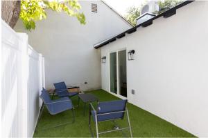 a patio with blue chairs and a table on the side of a building at Stellar Sherman Oaks One Bedroom close to Universal Studios in Burbank