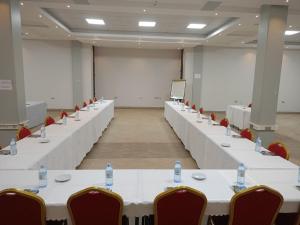 a conference room with white tables and chairs at HOTEL ZEPTAN in Jinja
