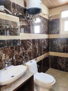 a bathroom with a toilet and a sink at The Summerlead, Shimla in Shimla +19 photos