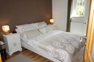 1 dormitorio con cama blanca y ventana en Ferienhaus Braunfels, en Braunfels