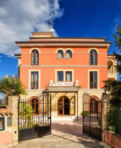 un edificio arancione con un cancello di fronte di Hotel Ristorante Casa Rossa ad Alba Adriatica