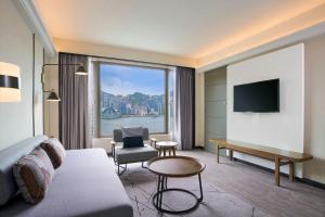 a hotel room with a couch and a large window at Sheraton Hong Kong Hotel & Towers in Hong Kong
