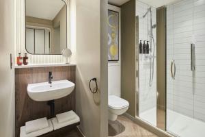 a bathroom with a sink and a toilet and a shower at Residence Inn by Marriott Edinburgh in Edinburgh +16 photos
