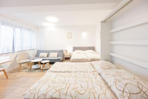 a white bedroom with a bed and a couch at Rezidence Sadová Zlín in Zlín