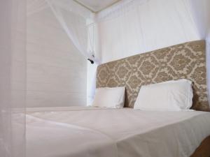 a white bed with white sheets and pillows at Why Not Guest house in Hikkaduwa