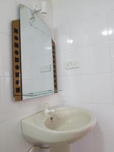 a white bathroom with a sink and a mirror at Why Not Guest house in Hikkaduwa