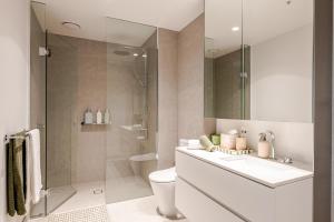 a bathroom with a toilet and a sink and a shower at Winx Trackside Moonee Ponds in Moonee Ponds