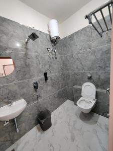 a bathroom with a toilet and a sink at Hotel Ekana in Chhatarpur