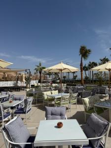 a patio with tables and chairs and umbrellas at بورتو سخنه in Ain Sokhna
