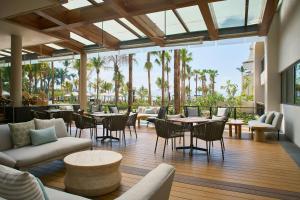 a restaurant with tables and chairs and palm trees at Marriott Puerto Vallarta Resort & Spa in Puerto Vallarta
