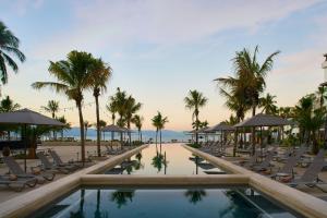 a resort pool with lounge chairs and palm trees at Marriott Puerto Vallarta Resort & Spa in Puerto Vallarta