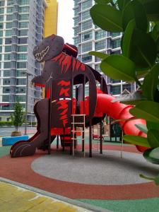 um parque infantil em frente a alguns edifícios altos em Shah Suites Vista Alam em Shah Alam