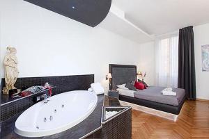 a large bathroom with a tub and a bed at Town House Fontana Di Trevi in Rome