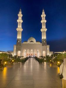 a mosque with two minarets and two towers at night at Izans Homestay Sendayan in Seremban