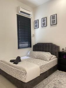 a bedroom with a bed and a window at Izans Homestay Sendayan in Seremban