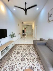 a living room with a couch and a flat screen tv at Izans Homestay Sendayan in Seremban