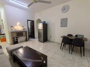 a living room with a table and a refrigerator at Catchy & Traveler-Friendly Room in Dibba