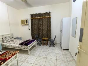 a room with a bed and a table and chairs at Catchy & Traveler-Friendly Room in Dibba