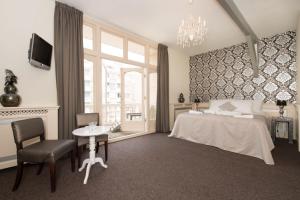 - une chambre avec un lit, une table et une fenêtre dans l'établissement Hotel & Appartementen Bella Vista, à Scheveningen