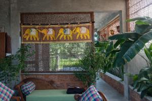 a room with a window with a couch and plants at Cinnamon Villas in Ambalangoda +16 photos