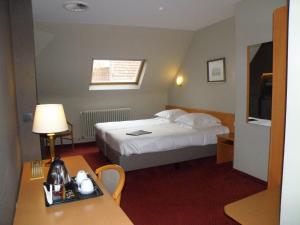 a hotel room with a bed and a desk at Albion Hotel in Ieper