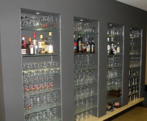 a wall filled with glasses of wine and alcohol at Albion Hotel in Ieper
