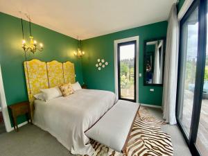 a bedroom with a bed and a green wall at Stablehouse Garden Shed in Masterton +13 photos