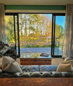 a living room with a couch and a large window at Stablehouse Garden Shed in Masterton