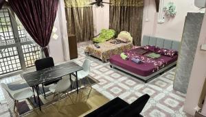 a living room with a bed and a table and chairs at Iltizam Guest House in Kuala Berang