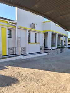 a large white building with yellow accents at Silk Mbare Guest House in Manzini
