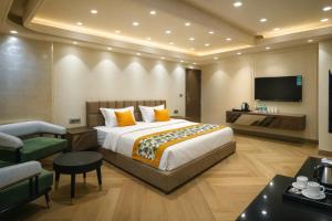 a hotel room with a bed and a tv at Qotel Signature Coleman Janakpuri Near District Centre & Pacific Mall in New Delhi