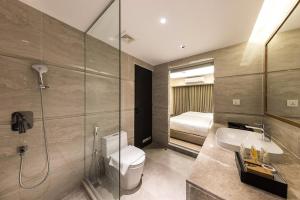a bathroom with a toilet and a sink and a shower at SureStay by Best Western in Cox's Bazar +43 photos