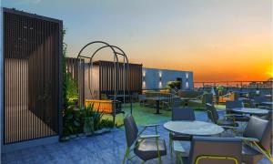a patio with tables and chairs with the sunset in the background at SureStay by Best Western in Cox's Bazar