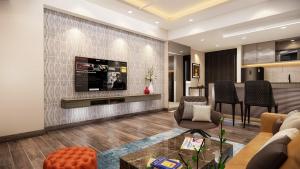 a living room with a couch and a tv on a wall at SureStay by Best Western in Cox's Bazar