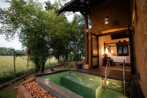 a guest house with a hot tub and a bedroom at Kirindi Paddy Isle - Boutique Villa in Negombo
