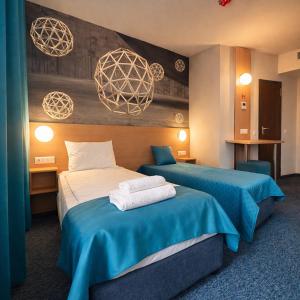 a hotel room with two beds with blue sheets at WESTGATE Hotel - FREE PARKING in Veliko Tŭrnovo