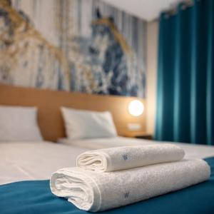 two towels sitting on top of a bed at WESTGATE Hotel - FREE PARKING in Veliko Tŭrnovo