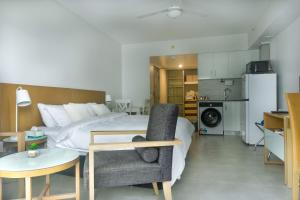 a bedroom with a bed and a table and a chair at Darwin Central Escape Hotel Style Apartment with Kitchen , Pool , Gym , Car Park,Balconey in Darwin