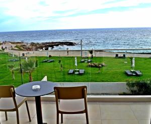a table and chairs and a view of the ocean at Amphora Hotel & Suites in Paphos