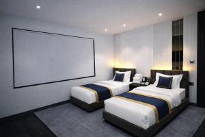 two beds in a hotel room with a large screen at Qotel Signature Coleman Janakpuri Near District Centre & Pacific Mall in New Delhi