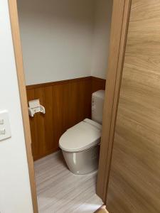 a small bathroom with a toilet in a room at Takamori Guest House in Takamori