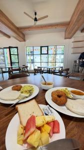 three plates of food on a wooden table at Samarya Chikkamagaluru in Chikmagalūr