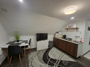 a small kitchen with a table and a small kitchen with a desk at Kakukkfészek Apartmanok in Kiskunmajsa