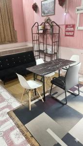 a table and chairs in a room with pink walls at Iltizam Guest House in Kuala Berang