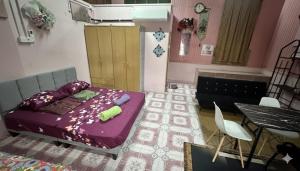 a bedroom with a purple bed and a table at Iltizam Guest House in Kuala Berang +2 photos