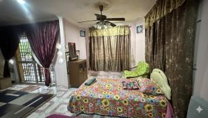 a bedroom with a bed and a ceiling fan at Iltizam Guest House in Kuala Berang