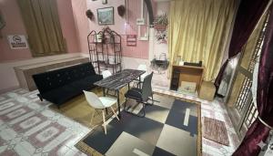 a living room with a couch and a table and chairs at Iltizam Guest House in Kuala Berang