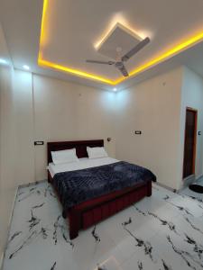a bedroom with a bed with a ceiling fan at Hotel Ekana in Chhatarpur