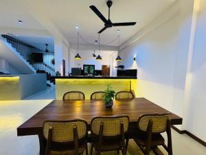 a dining room with a wooden table and chairs at Luma Malee Resort in Dickwella